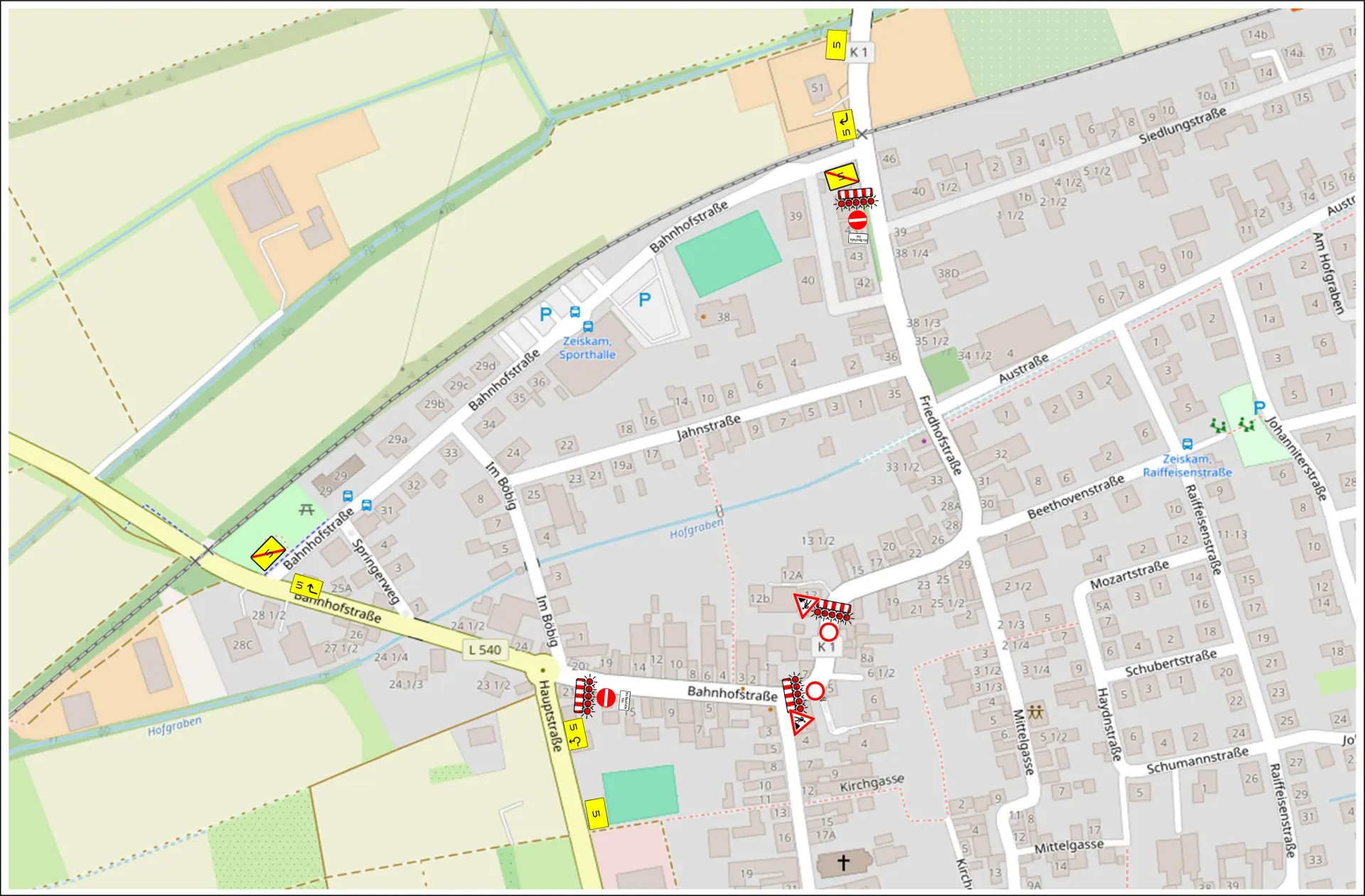 Umleitungsplan für eine Straßensperrung im Bereich Friedhofstraße und Bahnhofstraße in Zeiskam. Die Karte zeigt die gesperrten Straßenabschnitte sowie die ausgeschilderte Umleitungsstrecke über die Bahnhofstraße (L 540) und die Hauptstraße.