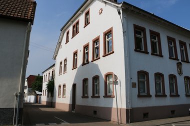 Außenansicht des katholischen Kindergartens St. Josef in Zeiskam, einem weißen mehrstöckigen Gebäude mit rot eingefassten Fenstern.