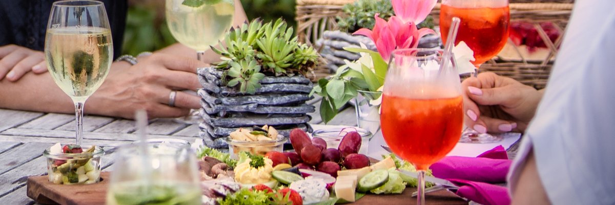 Picknick Bild mit 4 Menschen, welche in einem Biergarten zuprosten
