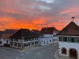 Sonnenaufgang über Ottersheim. Fachwerkhäuser und Straßen sind zu sehen